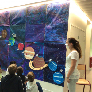 Fresque terminée - Le travail a été affiché dans le couloir des sciences. Les élèves et la peintre admirent leur travail.